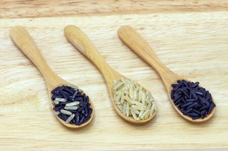 Rice Berry and Brown rice in a wooden spoon on the table.の写真素材