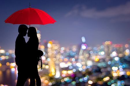 Silhouettes of couple against the blurred city, Romantic.の写真素材
