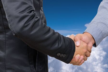 Double exposure of businessman handshake on sky background.の写真素材