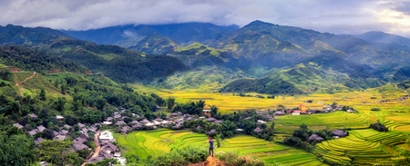 Travelers wearing a red cap overlooking rice fields on terraced of Mu Cang Chai, Yen Bai, Vietnam. Rice fields prepare the harvest at Northwest Vietnam.の写真素材