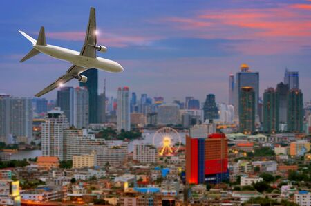 Airplane in the sky at sunset Flying over the city and river.の写真素材