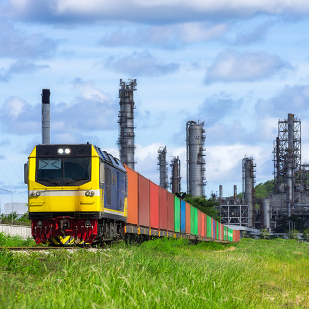 Rail freight, containers, against a backdrop of an oil refinery.の写真素材
