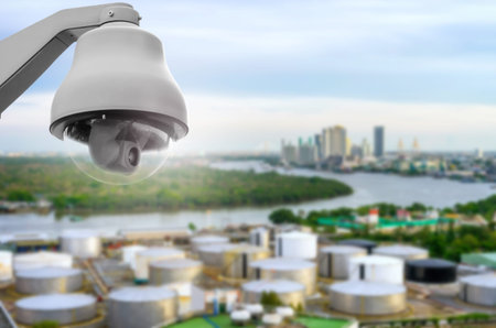 CCTV, security camera on blurred industrial background.
