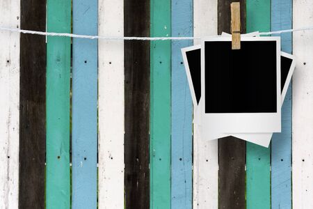 Clothespin hanging with blank photo papers on wooden background, with clipping path.の写真素材