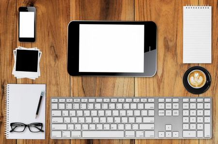 Top view desks with smartphone, keyboard, pencil, coffee mug, glasses, photo paper, Cassette Tapes and other business supplies.の写真素材