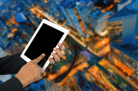 Businessman using tablet pc and city landscape at background.の写真素材
