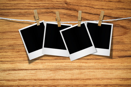 Blank photo frame with clothespin hanging on wooden background, with clipping path.の写真素材