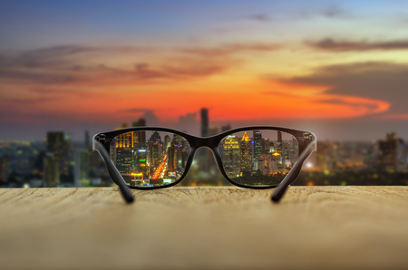 Clear cityscape focused in glasses lenses with blurred cityscape background.の写真素材