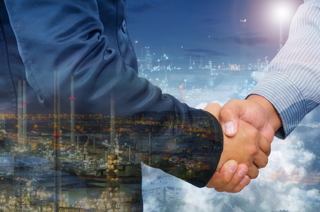 Double exposure of businessman handshake and industrial background.の写真素材