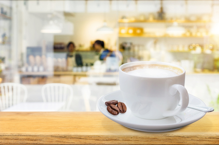 Coffee cup on the table with Blurred coffee shop backdrop.の写真素材