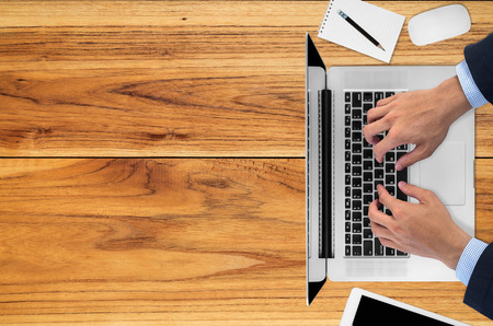 Office desk table with laptop, mouse, digital tablet, notepad, pencil and coffee cup, Top view with copy space.の写真素材