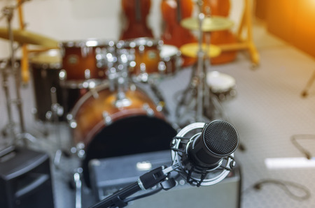Microphone in a recording studio or concert hall with drum in out of focus background.の写真素材