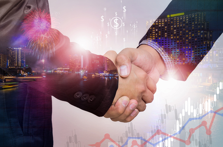 Double exposure of businessman handshake  with cityscape and financial graph on blurred building background.の写真素材