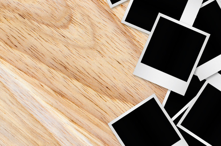 Blank photo papers isolated on wooden background with clipping path.の写真素材