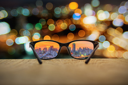 Clear cityscape focused in glasses lenses with blurred cityscape background.の写真素材