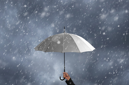 white umbrella in the hands of businessmen amid a rainstorm.の写真素材