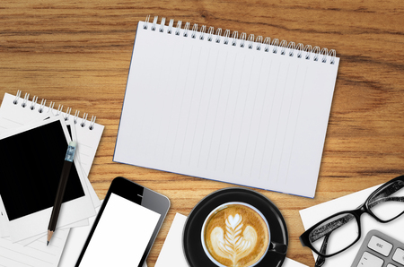 Top view desks with smartphone, keyboard, pencil, coffee mug, glasses, paper, Cassette Tapes, cake and other business supplies.の写真素材