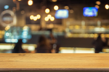 Empty wooden table and blurred Coffee shop interior background with bokeh image, for product display...