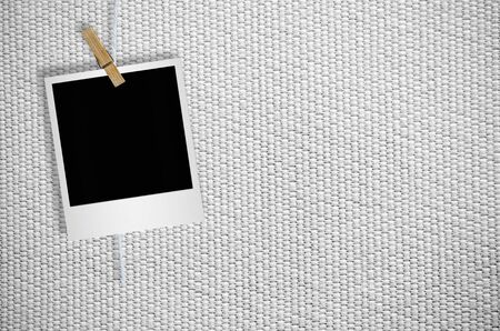 Blank photo frame with clothespin hanging on wooden backgroundの写真素材