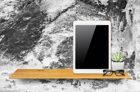 Digital tablet computer with isolated screen with clipping path on bookshelf in the wall.の写真素材