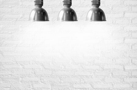 White brick wall illuminated by the ceiling lamp with copy space.の写真素材