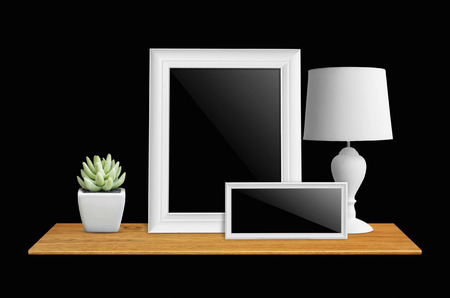 Empty picture frame isolated with clipping path, lamps and potted cactus on bookshelf  - For product display.の写真素材