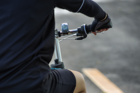 Behind the Asian women cyclists gloved hand on the handlebars of the bike. Side of the roadの写真素材