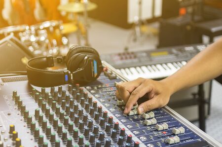 Closeup Hand adjusting audio mixer, music instrument conceptの写真素材
