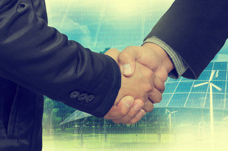 Double Exposure of a businessman handshake on the background blurred. Concept of an agreement green energy. Vintage Style.の写真素材