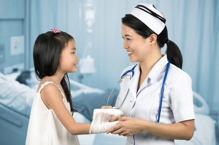 Asian nurse in uniform pediatric care girls with background blur patient room.の写真素材