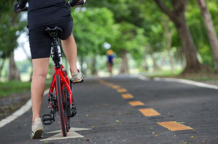Behind the Asian women cyclists gloved hand on the handlebars of the bike.の写真素材