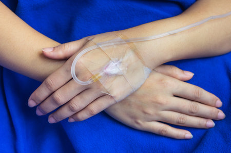 Close-up of hands patient received saline via cable in the patient rooms.