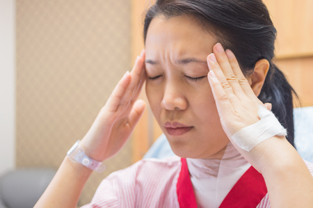 Female patients with headaches in the hospital room.の写真素材