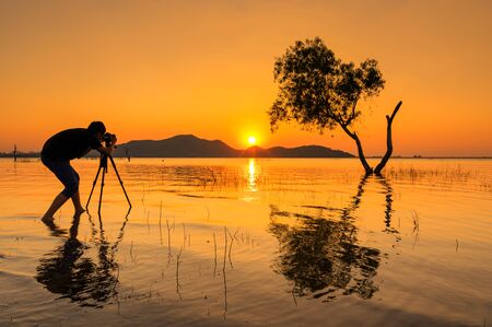 Silhouette of photographer shooting sunset Chon Buri Bang Phra reservoir.の写真素材