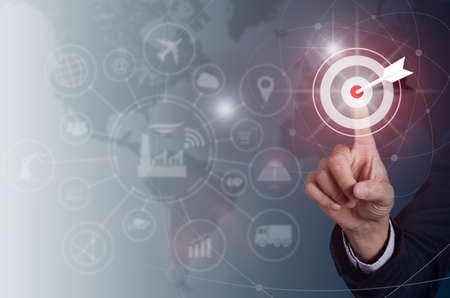Businessman pressing button goal on virtual screen, Success concept, technology industry 4.0 and world maps on the background.の写真素材