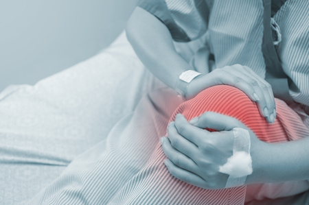 Female patients with knee pain in the hospital room.の写真素材