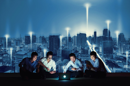 Asian business group in casual suits using smartphone, tablet and laptop for working or playing social networks and wep site on high-rise rooftop sites. Business and technology concept.
の写真素材