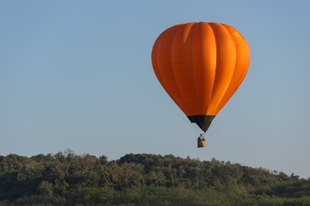Beautiful Orange Hot air balloon in the blue sky at Balloon festival in Chiang rai, Thailand.の写真素材