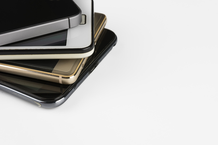 Stack of high-end smartphones on white desk.の写真素材