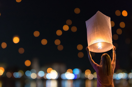 Women are releasing floating lanterns in the Loy Krathong festival or floating lanterns festival in Chiang Mai, Thailand.の写真素材