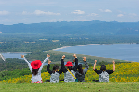 Young women group happy relax, (Tung Bua Tong) Mexican sunflower field in Mae Moh Coal Mine, Lampang Province, Thailand.の写真素材