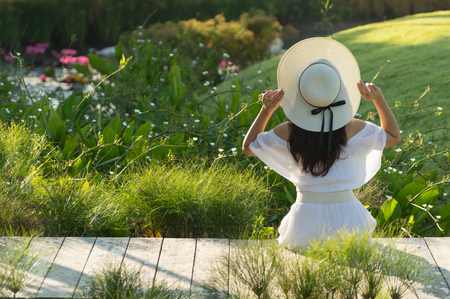 Beautiful young asian girl relaxing in resort wearing white dress at morning time.の写真素材