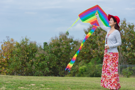 Women wearing red dress and happy with a kite on clear day.の写真素材