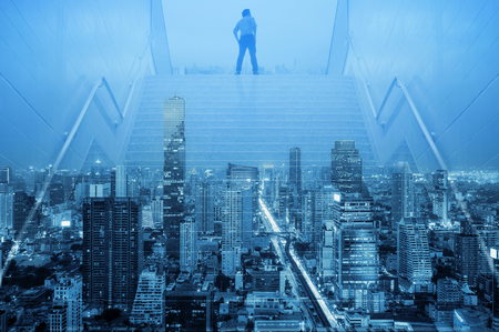 Businessman climbed on top of the stairs going to the city, Ambitions concept and Success business, Double Exposure Effect bule tone.の写真素材