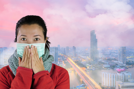 Asian women wear masks to prevent air pollution with background against "Toxic dust" covered the city of Bangkok has a health effect.の写真素材