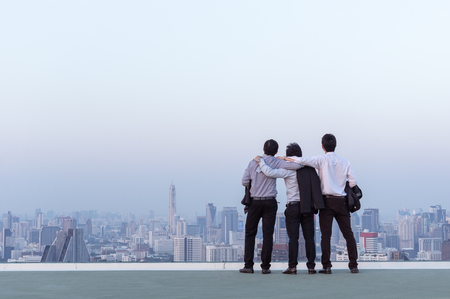 Business teamwork concept, businessman standing at the top of the building and looking through the cityscape.の写真素材
