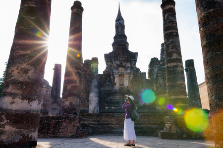 Asian women tourists stand and shooting images at Wat Mahathat in the Sukhothai Historical Parkの写真素材