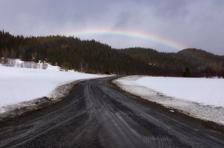 Beautiful road into mountain view with rainbow of scenic Lofoten Islands archipelago winter scenery, Beautiful mountain landscape in winter Norway, Scandinavia.の写真素材