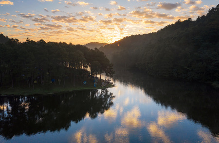Aerial view, Camping and tent under the pine forest in Beautiful sunrise at Pang Oung (Pang Tong reservoir), lake with reflection of pine tree in a lake, Pang Oung Mae Hong Son province, thailand.の写真素材