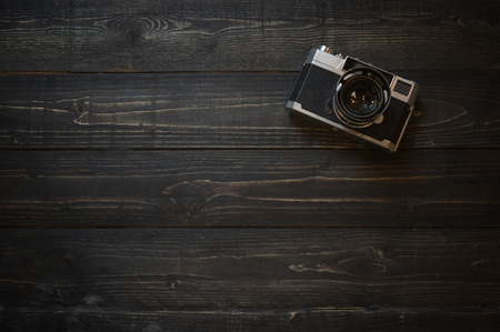 Retro camera of travel accessory on wooden background top view,in vintage tone style copy space.の写真素材